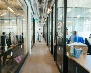 Moderne kantoorruimte aan de Stadhouderskade in Amsterdam met glazen wanden en werkende mensen in verschillende kantoren.