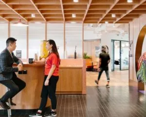 Moderne kantoorruimte aan de Stadhouderskade 5 in Amsterdam met mensen bij een bar en open werkplekken op de achtergrond.