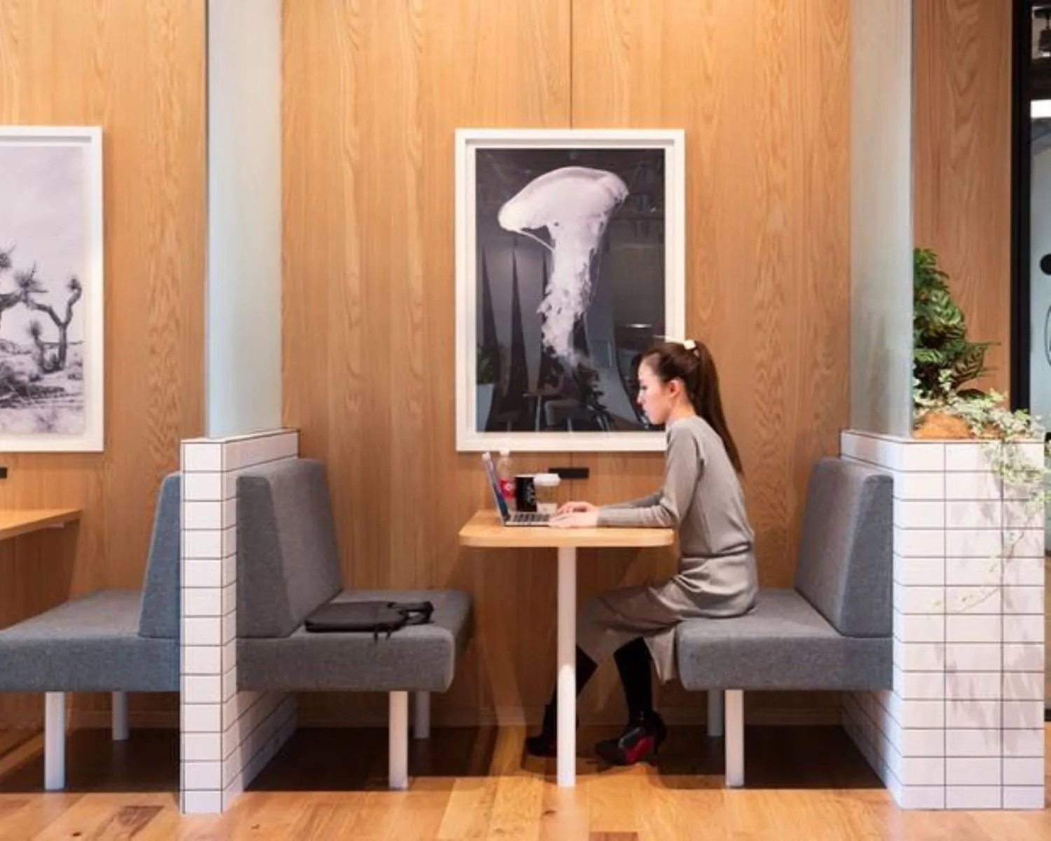 Vrouw werkt op laptop in moderne kantoorruimte aan de Stadhouderskade in Amsterdam.