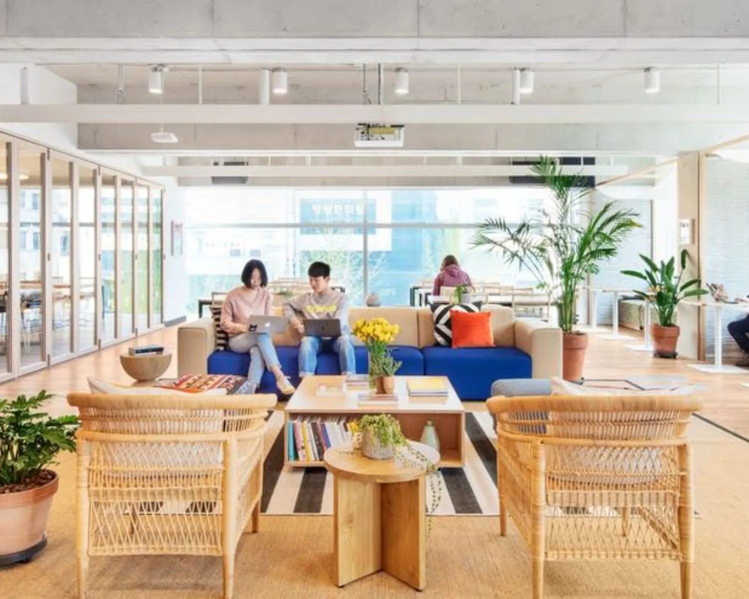 Moderne en lichte kantoorruimte aan de Stadhouderskade 5 in Amsterdam met zitgedeelte, planten en werkende mensen.