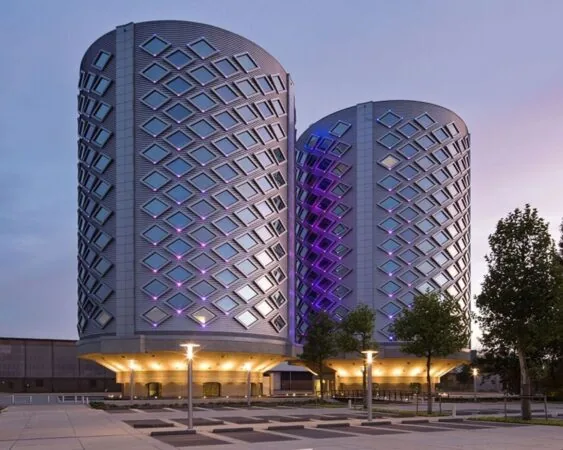 Twee moderne kantoorgebouwen van SugarCity in Halfweg met opvallende gevelverlichting in het schemerlicht.