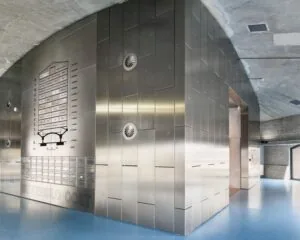 Moderne entreehal van kantoorgebouw Suikersilo Oost in SugarCity met metalen wand en blauwe vloer.