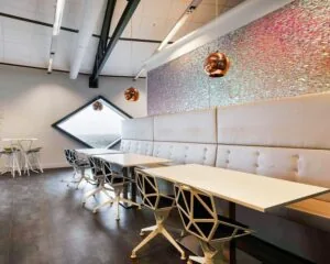 Moderne kantoorruimte in SugarCity Halfweg met strakke inrichting, designstoelen en opvallende wanddecoratie.