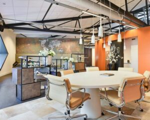 Moderne kantoorruimte in SugarCity Halfweg met een ronde vergadertafel, designstoelen en industriële accenten.