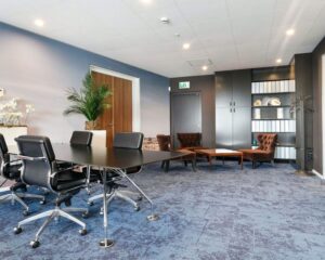 Moderne kantoorruimte in SugarCity Halfweg met vergadertafel, loungehoek en opbergkasten.