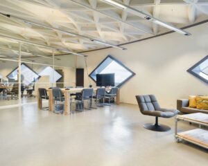 Moderne kantoorruimte in SugarCity Halfweg met vergadertafel, loungehoek en diamantvormige ramen.