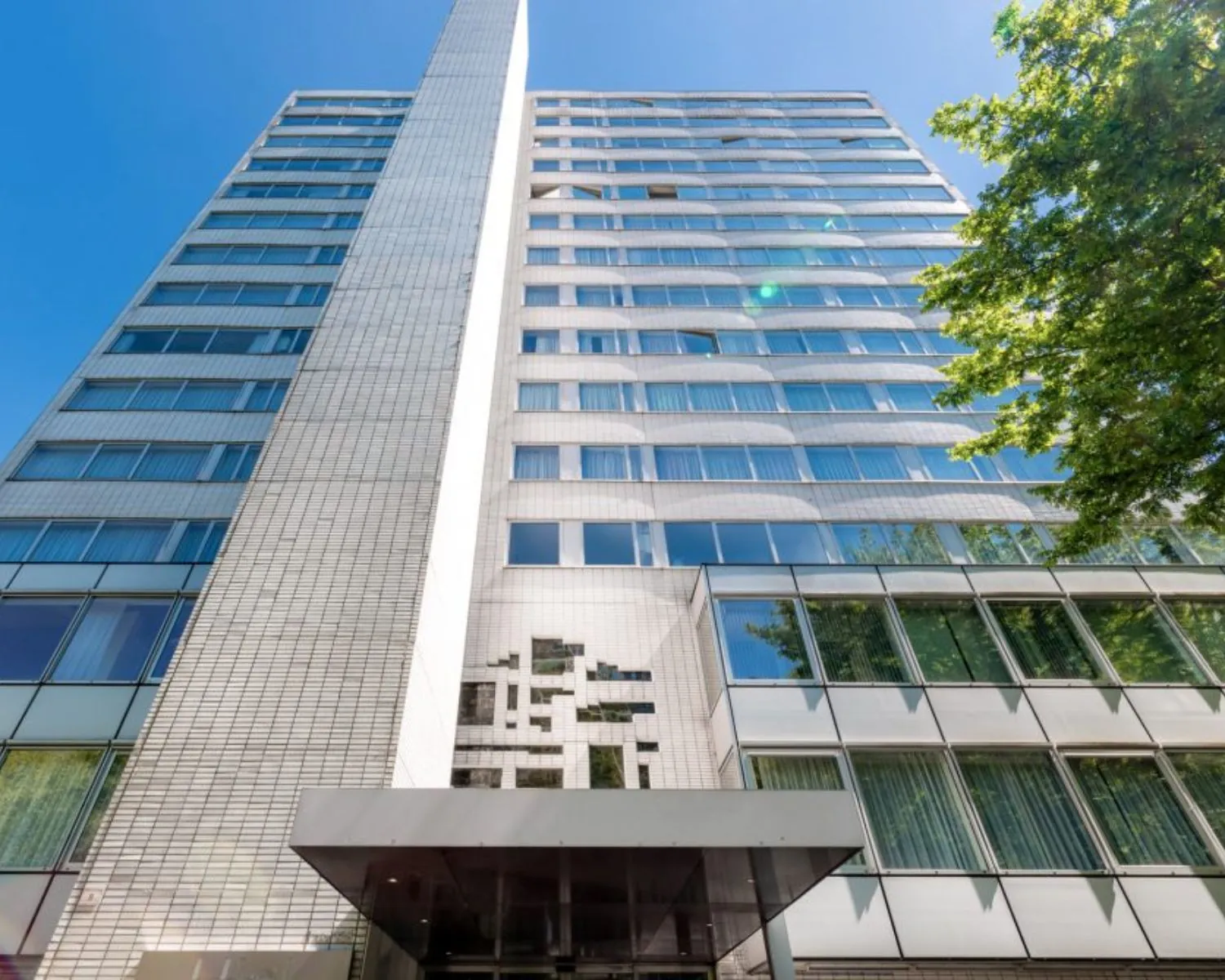 Voorgevel van een modern kantoorgebouw in Teijlingen met glazen ramen en strakke witte gevelbekleding.