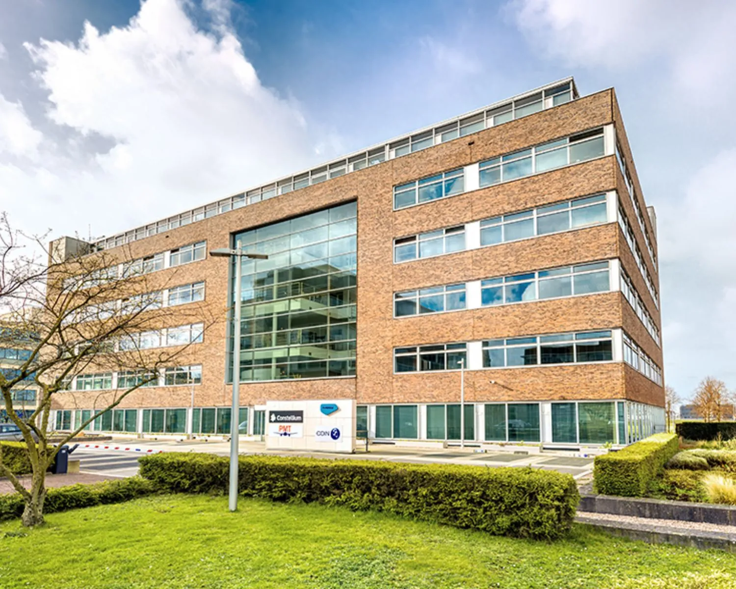 Modern kantoorgebouw aan de Tupolevlaan 41 in Schiphol met grote ramen en een bakstenen gevel.