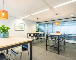 Moderne, lichte kantoorruimte aan de Tupolevlaan 41 in Schiphol met hoge tafels, barkrukken en kleurrijke hanglampen.