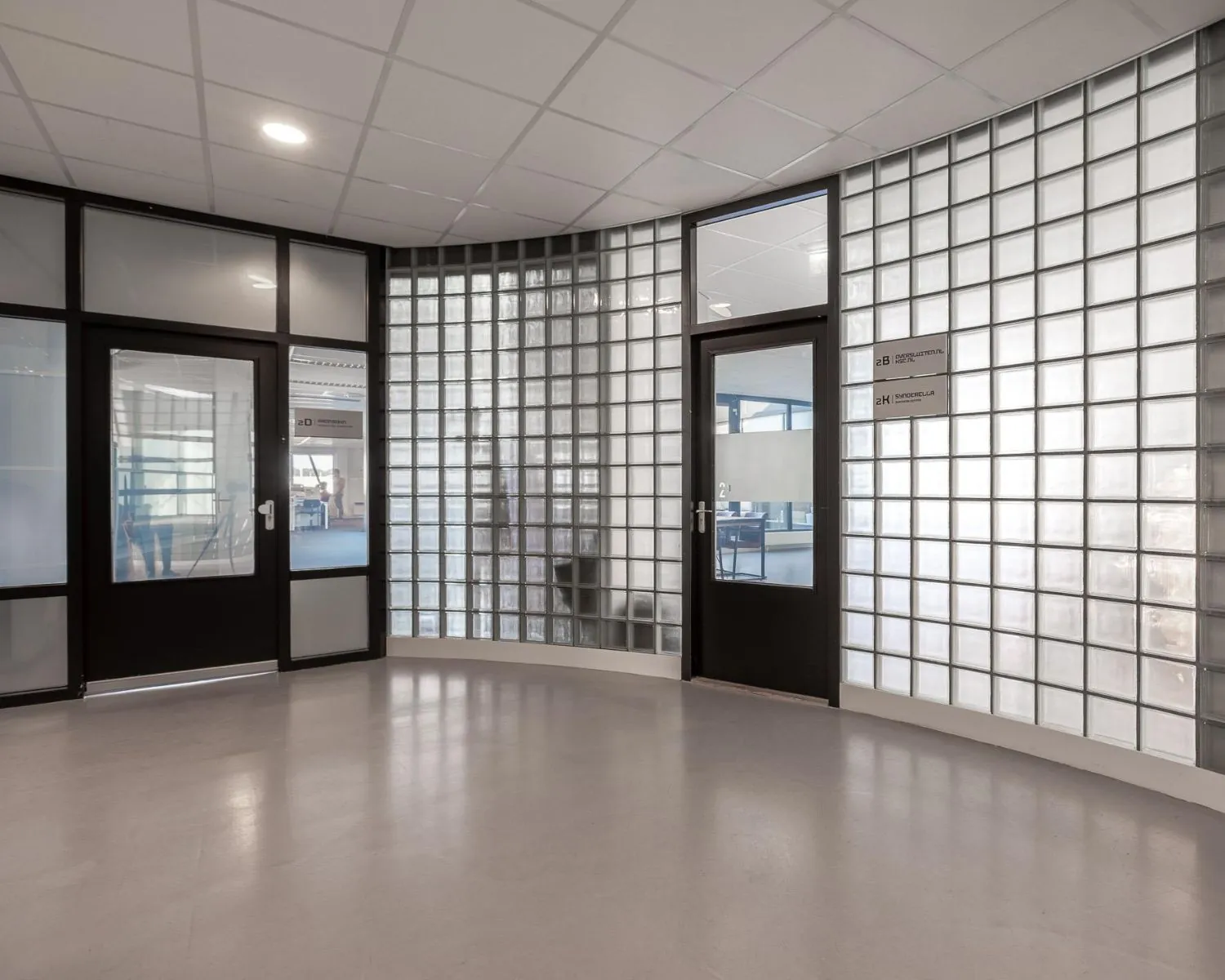 Moderne kantoorruimte met glazen bouwstenen en zwarte deuren aan de Ukkelstraat 2 in Eindhoven.