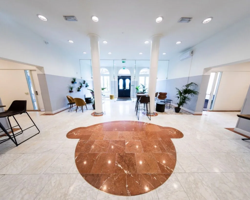 Moderne en lichte kantoorruimte met marmeren vloer en loungehoek aan het Westplein 12-14 in Rotterdam.