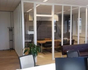 Moderne kantoorruimte aan de Zekeringstraat 17 in Amsterdam met glazen vergaderruimte en houten vloer.