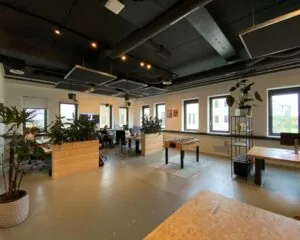 Moderne kantoorruimte aan de Zekeringstraat 17 in Amsterdam met open werkplekken, planten en een tafelvoetbaltafel.