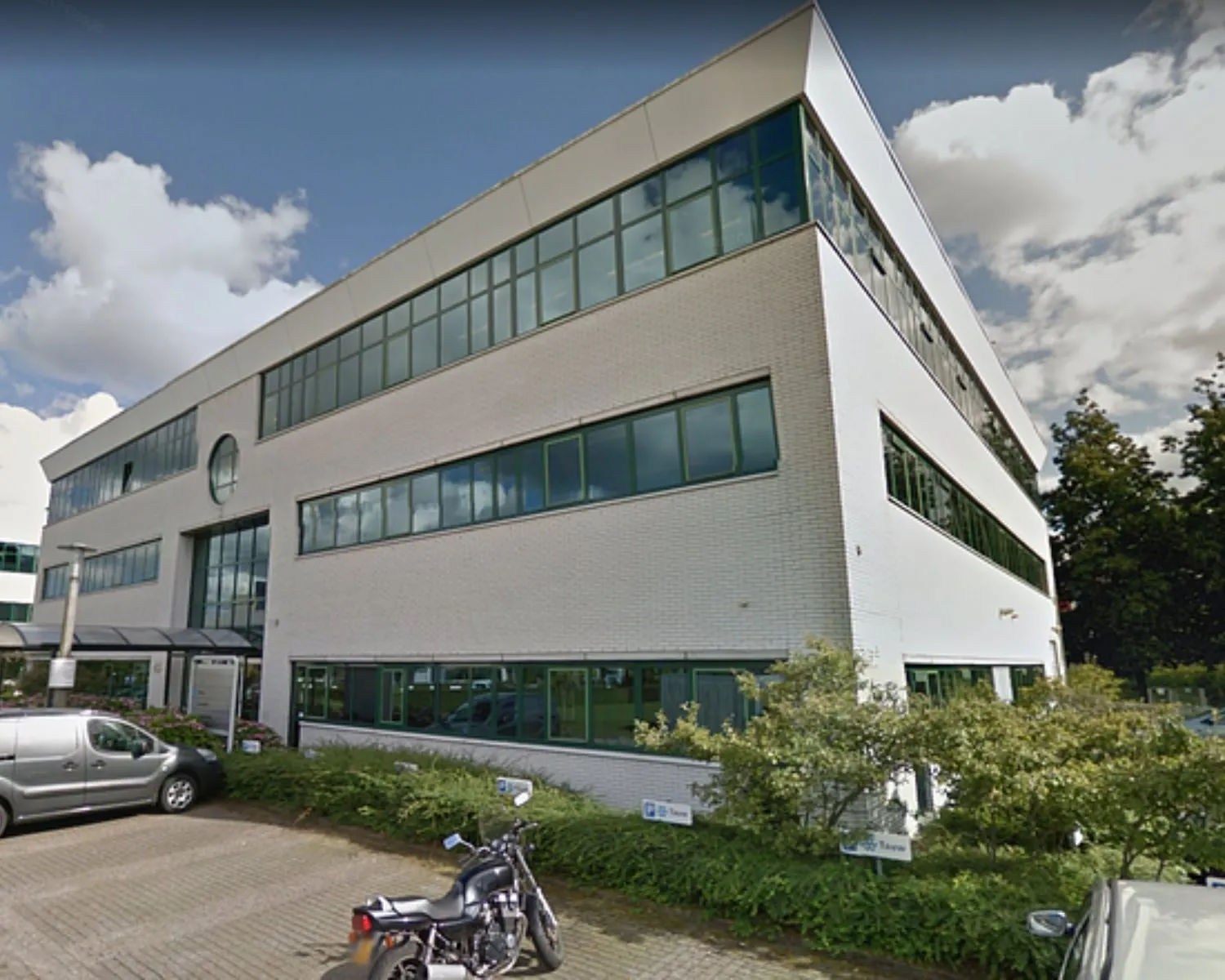 Modern wit kantoorgebouw aan de Zekeringstraat 43 in Amsterdam met grote ramen en parkeergelegenheid ervoor.