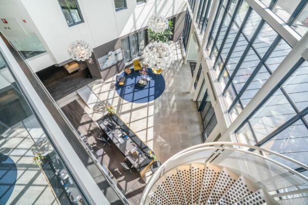 Lichte en moderne kantoorlobby van Kanaalpark 140 met grote raampartijen, zithoek en wenteltrap.