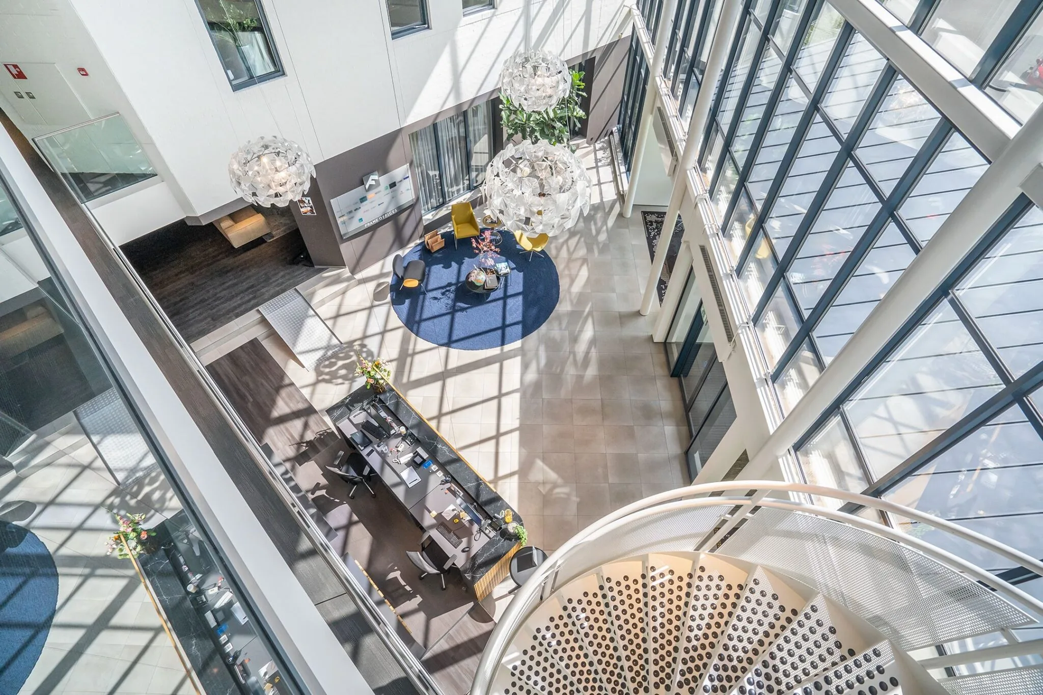 Lichte en moderne kantoorlobby van Kanaalpark 140 met grote raampartijen, zithoek en wenteltrap.