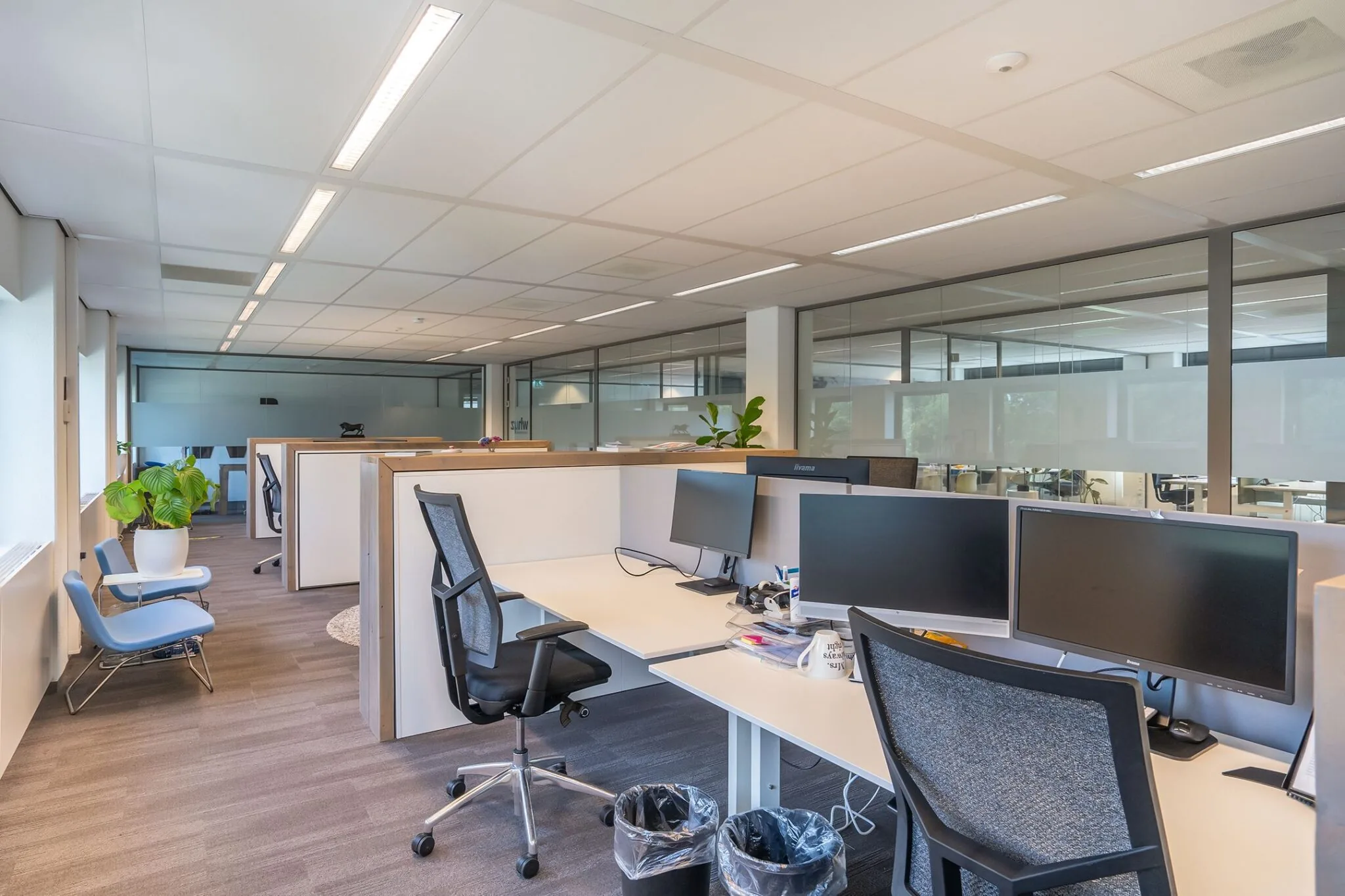 Moderne, open kantoorruimte op Kanaalpark 140 met werkplekken, bureaustoelen, beeldschermen en glazen wanden.