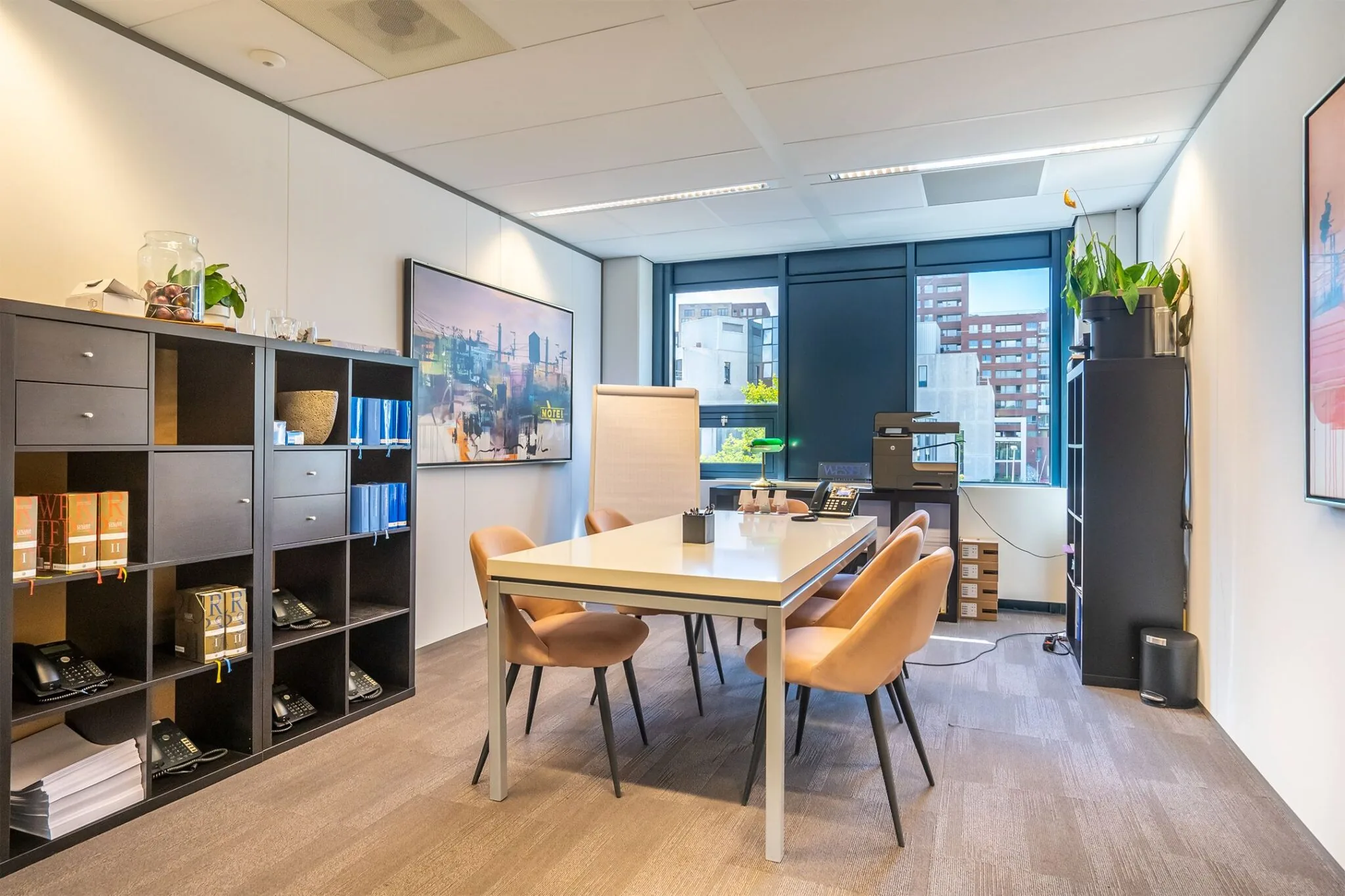 Vergaderruimte in een modern kantoor aan Kanaalpark 140 met tafel, stoelen, kasten en uitzicht op omliggende gebouwen.