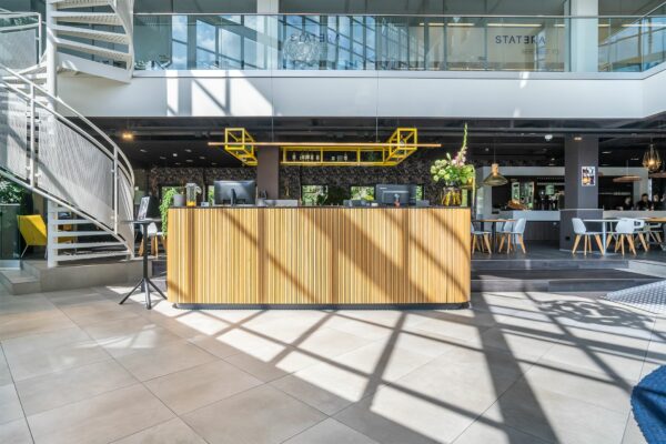 Moderne receptiebalie met houten afwerking in een lichte, open kantoorruimte in Kanaalpark 140.