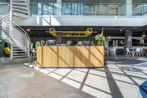 Moderne receptiebalie met houten afwerking in een lichte, open kantoorruimte in Kanaalpark 140.