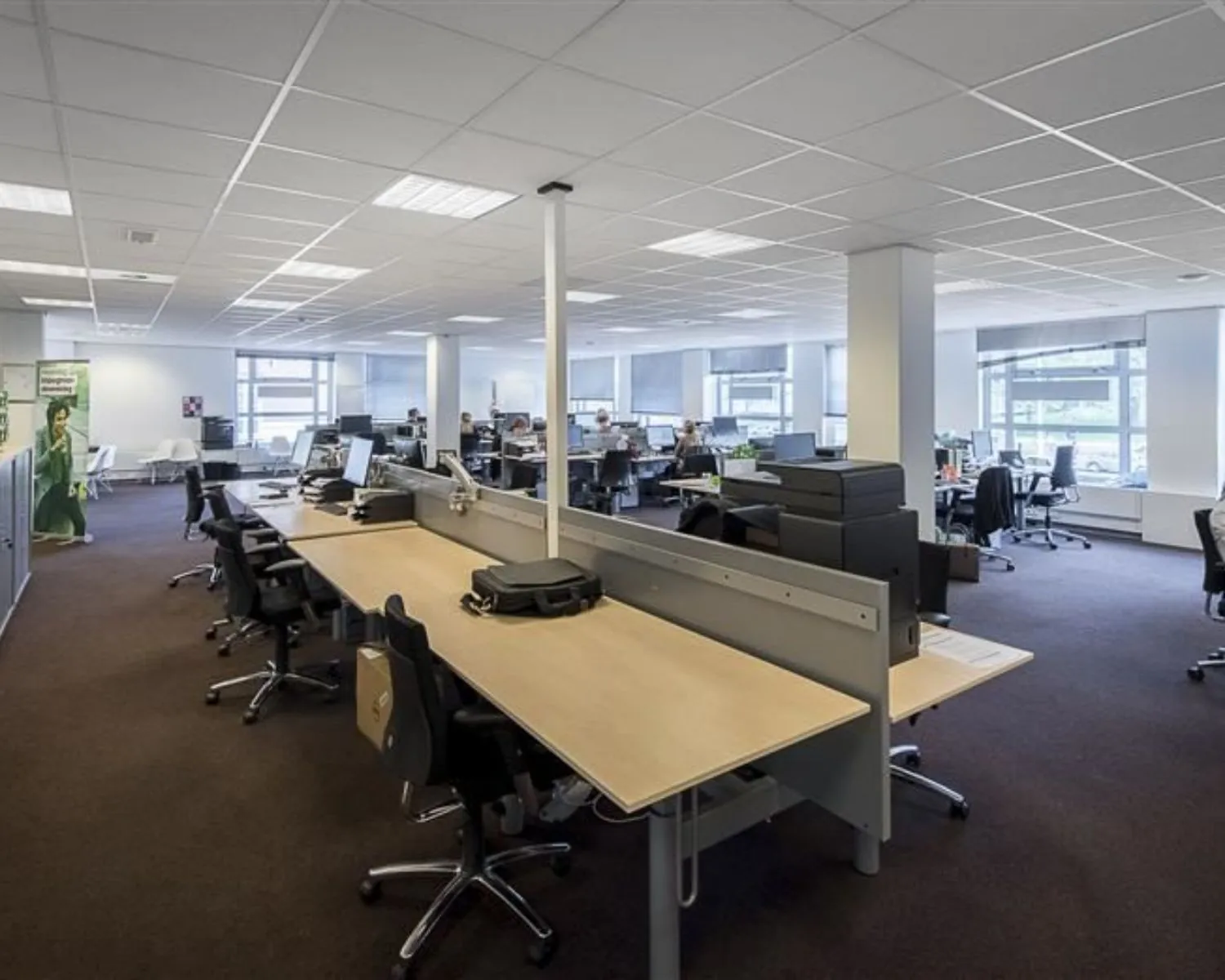 Ruim modern kantoorpand met open werkplekken en bureaus in een lichte, open inrichting.