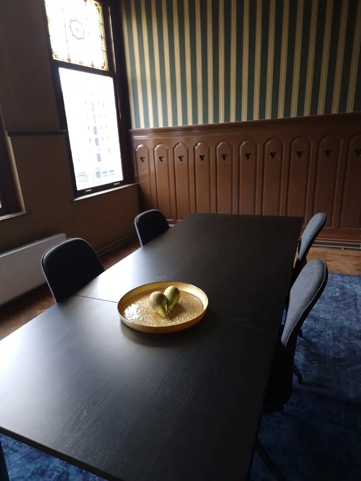 Stijlvolle vergaderruimte aan de Aelberchtskolk 45b1 in Rotterdam met donkere tafel, moderne stoelen en decoratief dienblad.