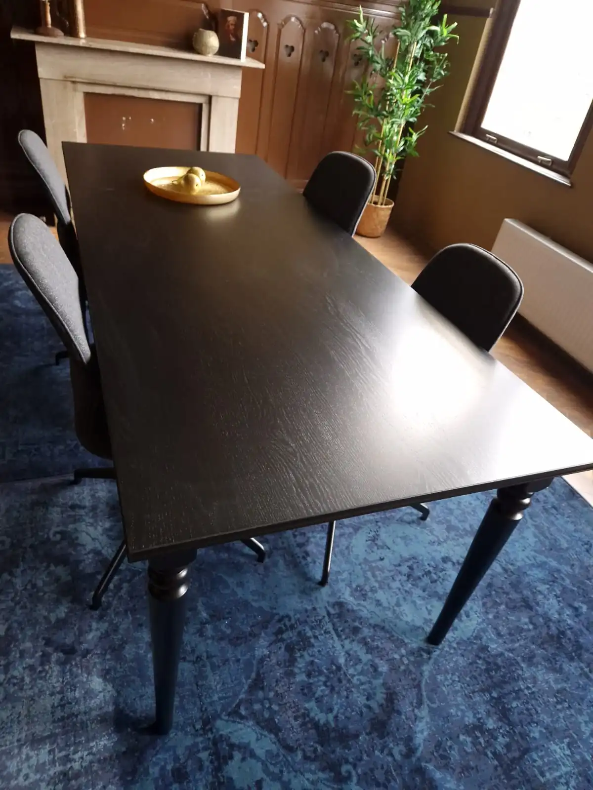 Moderne vergaderruimte met een zwarte tafel, vier stoelen en een gouden schaal, gelegen aan de Aelberchtskolk 45b1 in Rotterdam.