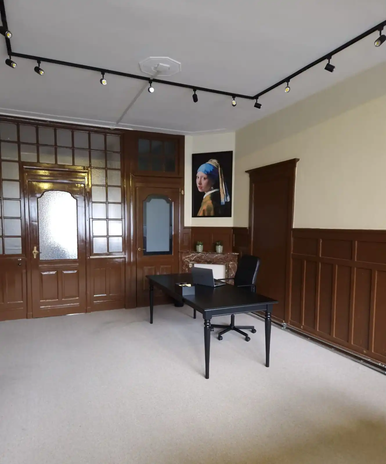 Stijlvol ingerichte kantoorruimte met zwart bureau en schilderij aan de muur, gelegen aan de Aelberchtskolk 45b1 in Rotterdam.