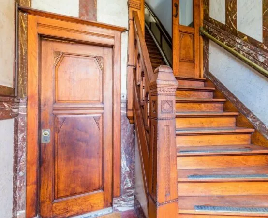 Trapopgang en deur met klassiek houten interieur in kantoorpand aan de Aelberchtskolk 45b1 in Rotterdam.