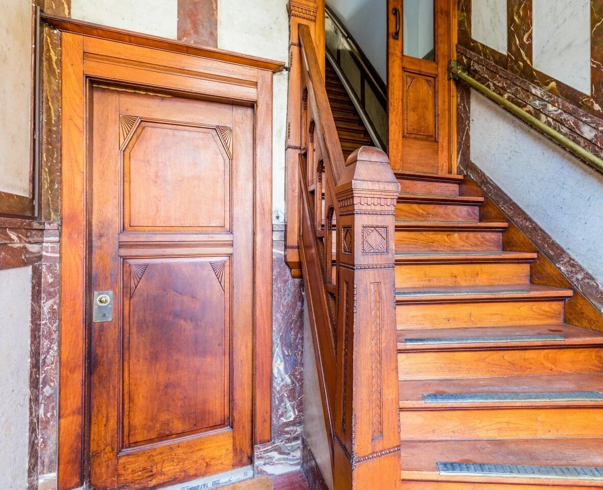 Trapopgang en deur met klassiek houten interieur in kantoorpand aan de Aelberchtskolk 45b1 in Rotterdam.