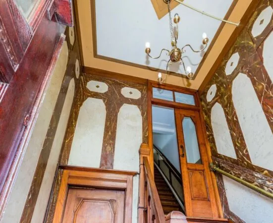 Trapopgang met houten afwerking en glas-in-looddeur in kantoorruimte aan de Aelberchtskolk 45b1 in Rotterdam.