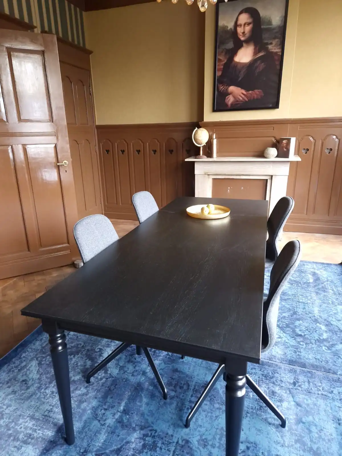 Stijlvol ingerichte kantoorruimte aan de Aelberchtskolk 45b1 in Rotterdam met zwarte vergadertafel, grijze stoelen en een schilderij van de Mona Lisa aan de muur.