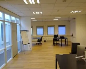 Moderne, lichte kantoorruimte met houten vloer en meerdere werkplekken aan de Amstel 62 in Amsterdam.