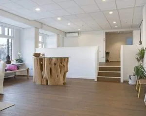 Moderne, lichte kantoorruimte aan de Amstel in Amsterdam met houten vloer, design tafel en witte muren.