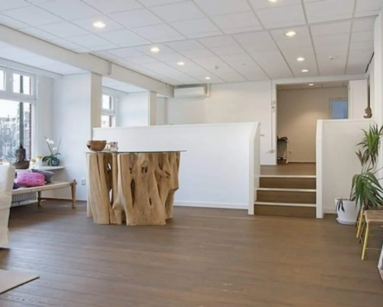 Moderne, lichte kantoorruimte aan de Amstel in Amsterdam met houten vloer, design tafel en witte muren.