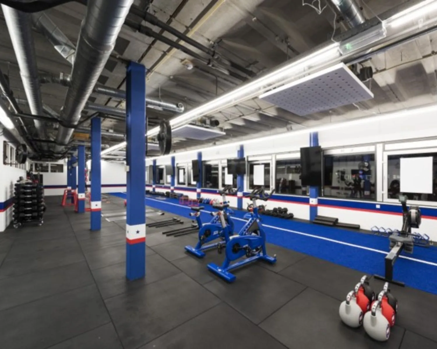 Moderne fitnessruimte in een kantoorpand aan de Hogehilweg 20 in Amsterdam met cardio- en krachttrainingsapparatuur.