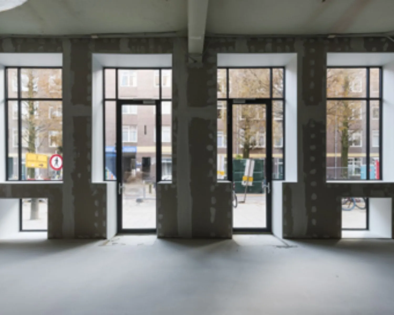 Lege kantoorruimte in aanbouw met grote ramen aan de Karel du Jardinstraat in Amsterdam.