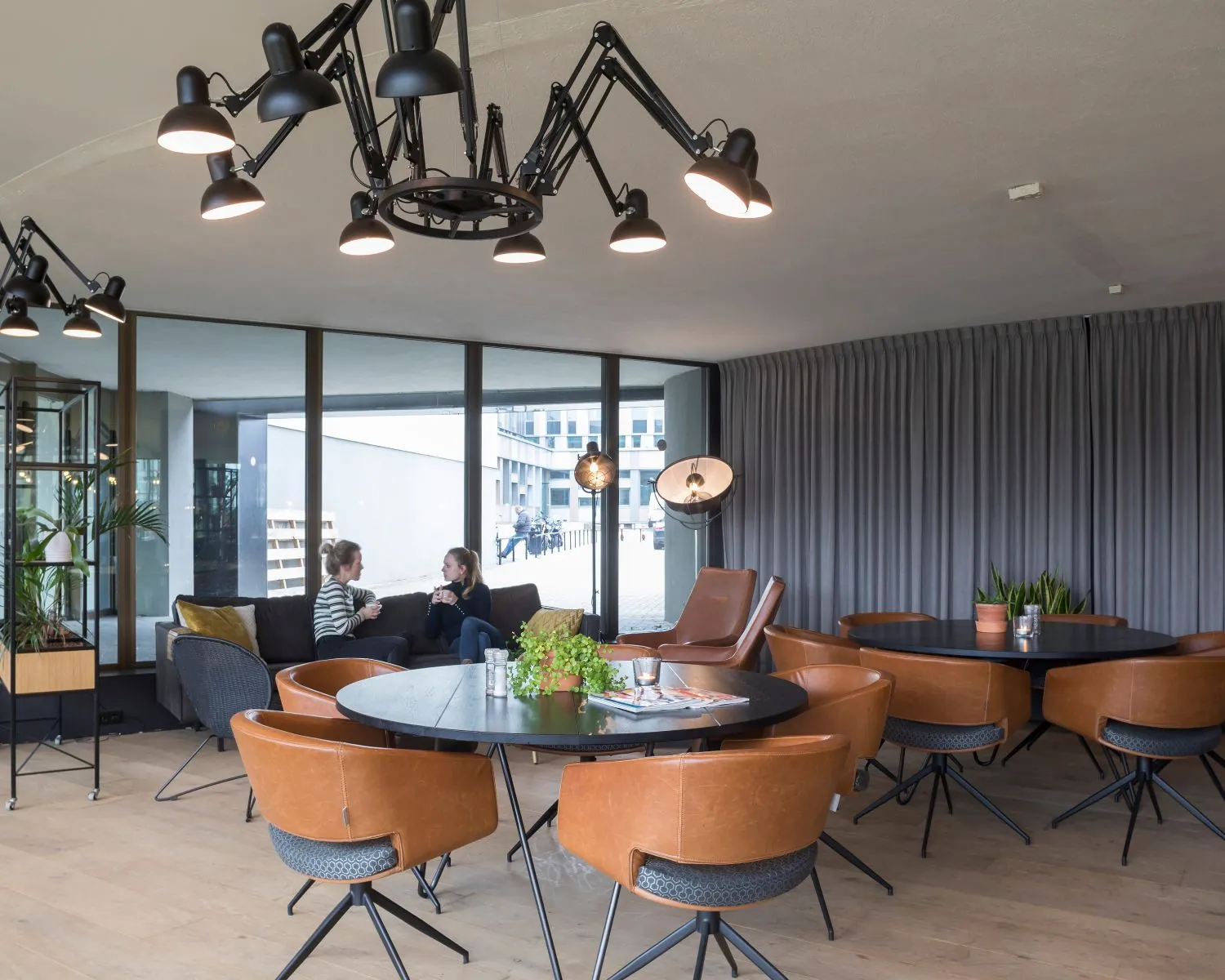 Moderne en sfeervolle kantoorruimte met zithoeken, ronde tafels en grote ramen aan de Assendorperdijk 1 in Zwolle.