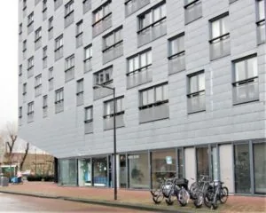 Moderne kantoorruimte aan de Baron G.A. Tindalstraat 242-244 met fietsen voor de ingang en grote ramen op de begane grond.