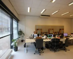 Moderne kantoorruimte aan de Baron G.A. Tindalstraat met meerdere werkplekken en grote ramen met uitzicht op de straat.