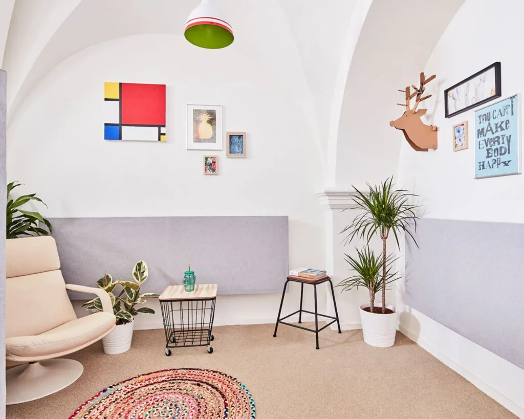 Stijlvol ingerichte kantoorruimte aan de Batjanstraat 11 in Amsterdam met moderne meubels, planten en kleurrijke muurdecoratie.