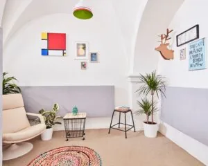 Stijlvol ingerichte kantoorruimte aan de Batjanstraat 11 in Amsterdam met moderne meubels, planten en kleurrijke muurdecoratie.