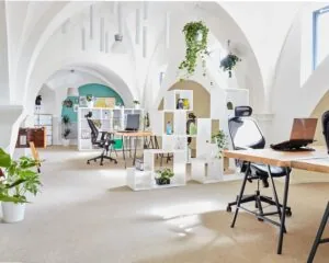 Lichte en moderne kantoorruimte met hoge gewelfde plafonds, planten en flexibele werkplekken aan de Batjanstraat 11 in Amsterdam.