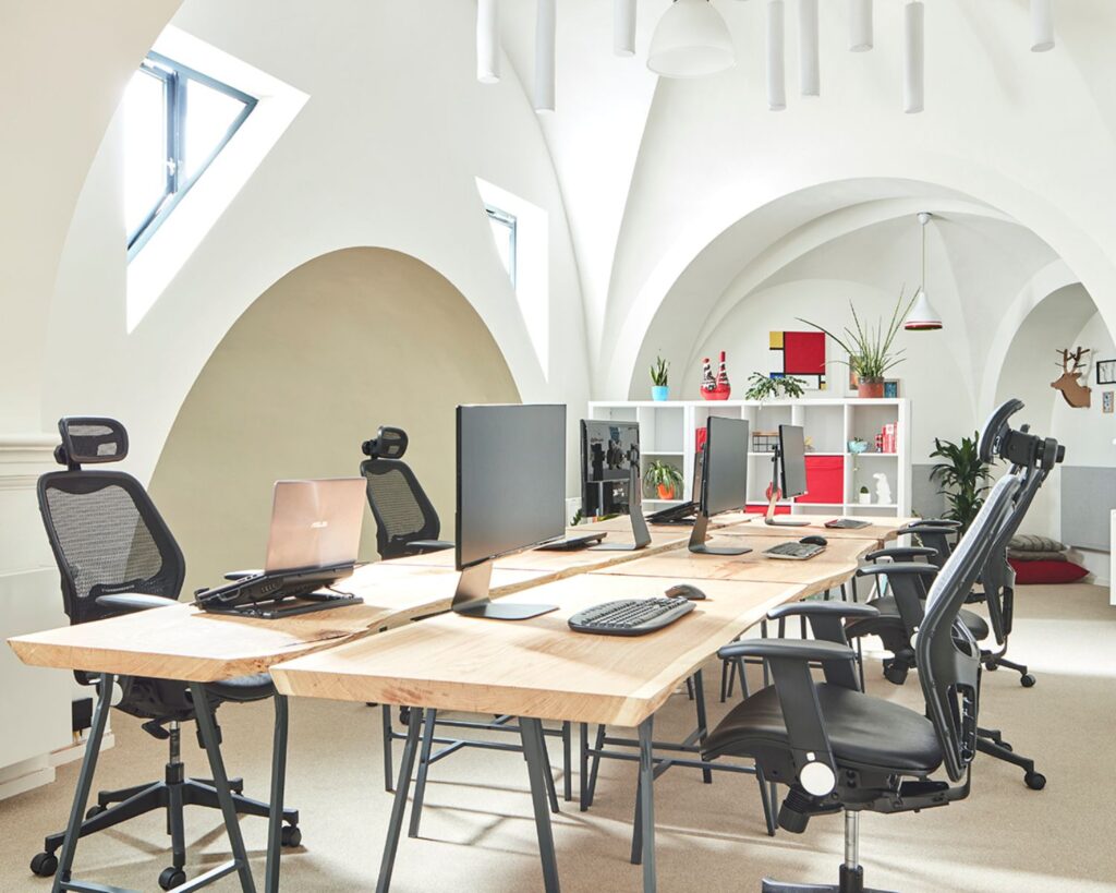 Moderne en lichte kantoorruimte met houten bureaus en ergonomische bureaustoelen aan de Batjanstraat 11 in Amsterdam.
