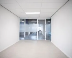 Lege kantoorruimte met glazen wand en deur aan de Bingerweg 18.