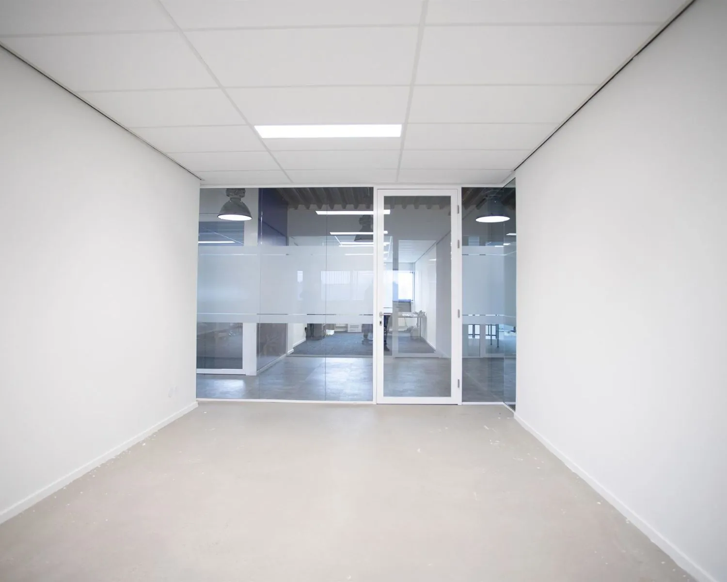 Lege kantoorruimte met glazen wand en deur aan de Bingerweg 18.