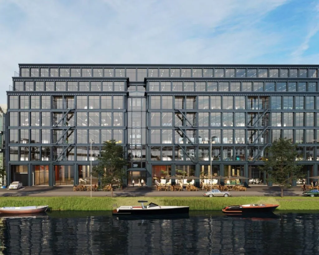 Modern kantoorgebouw aan het water op Danzigerkade 14-15 in Amsterdam met glazen gevel en terrassen aan de kade.