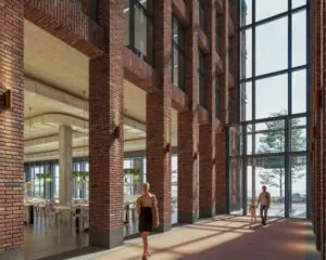 Moderne entreehal met hoge ramen en bakstenen muren in kantoorgebouw aan de Danzigerkade 14-15 in Amsterdam.