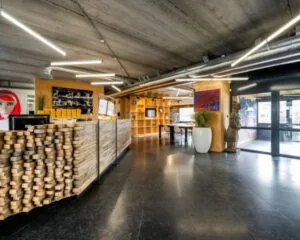 Moderne en creatieve kantoorruimte in Diemermere 1 in Diemen met houten receptiebalie, kunstobjecten en open zithoek.