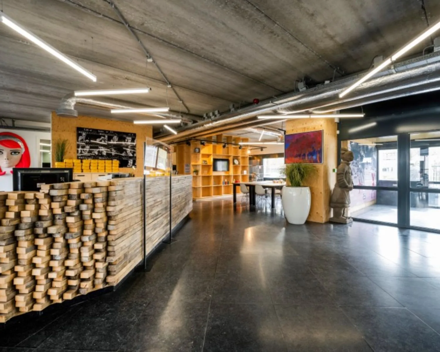 Moderne en creatieve kantoorruimte in Diemermere 1 in Diemen met houten receptiebalie, kunstobjecten en open zithoek.
